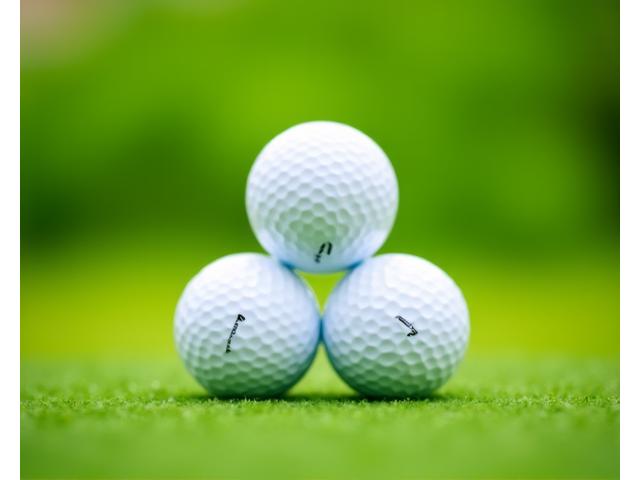 A pyramid of three premium golf balls.